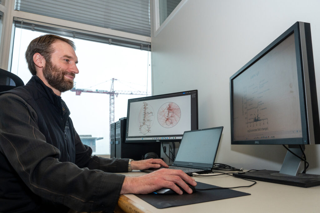 Photo of Kevin Hicks, PhD, at computer for "Finding Inspiration for Drug Development in Metabolic Regulators" entry