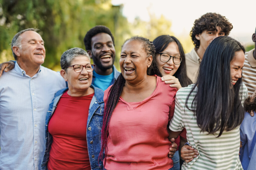 Photo for "Uncovering Disparities that Impact Heart Health" entry, featuring happy multi generational people having fun together at city park while hugging each other.